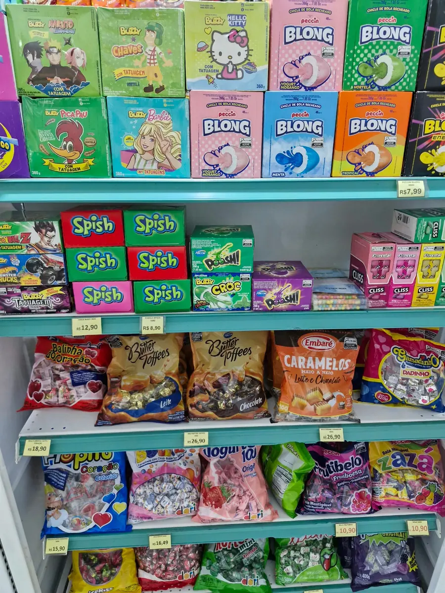 Caixas de chicletes e pacotes de caramelos e balas.