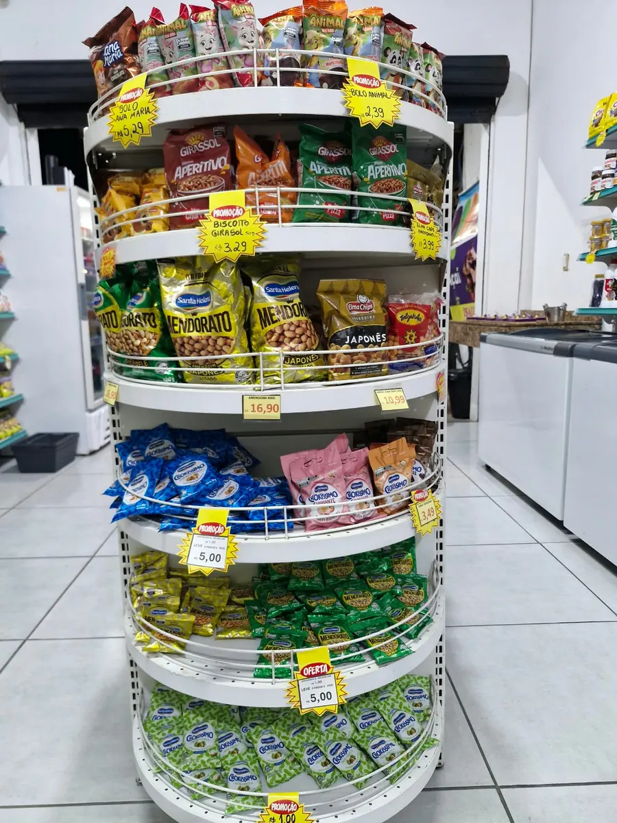 Expositor com amendoins, aperitivos, biscoitos e bolinhos embalados.